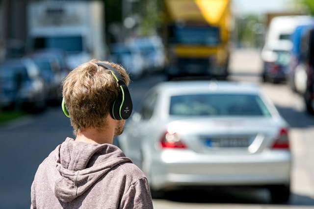 Fußgänger mit Kopfhörern auf will Straße überqueren