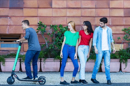 E-Scooter-Fahrer passiert lässig drei junge Leute