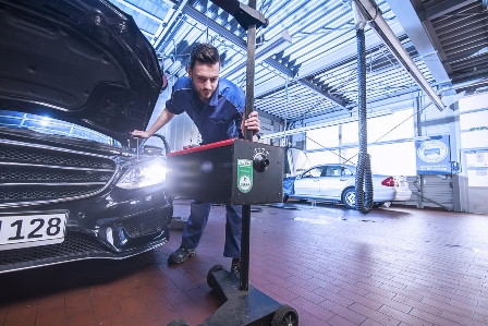 Kfz-Mechatroniker prüft Hauptscheinwerfer