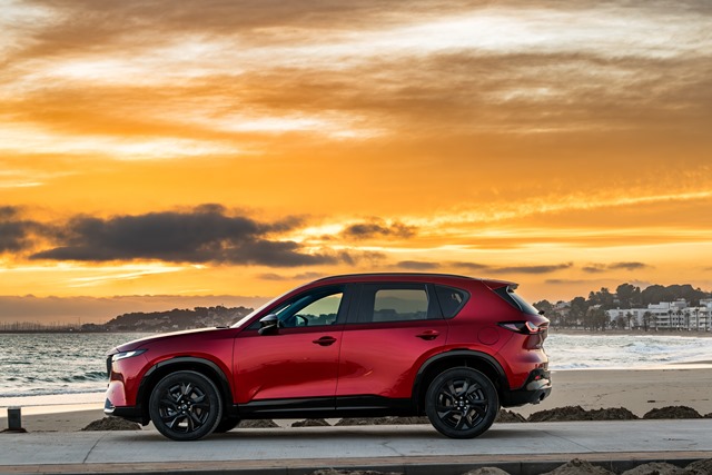 Neuer Mazda CX-5 in Metallic-Rot am Meer beim Sonnenuntergang