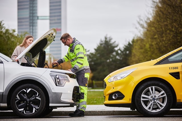 Gelber Engel steht an offener Motorhaube